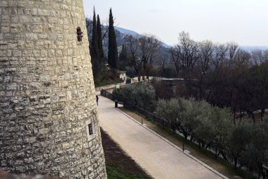 Yukarıdan görünen bir parktaki çakıl yolu bir şatonun taş kulesi tarafından çerçevelenmiş.