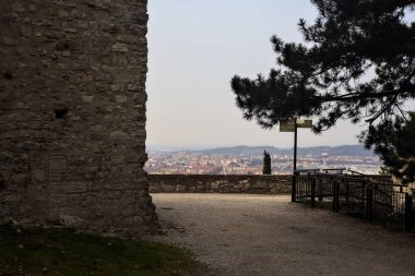 Balustrade ağaçların yanında bir şatonun parkında, yukarıdan arka plan olarak görünen bir şehir.