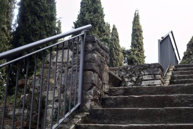 Parktaki bir kalenin sınır duvarının yanındaki taş merdiven.