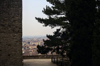Balustrade ağaçların yanında bir şatonun parkında, yukarıdan arka plan olarak görünen bir şehir.