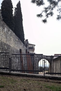 Taş köprü ve bulutlu bir günde uzaklardan görünen bir kalenin kapısı.