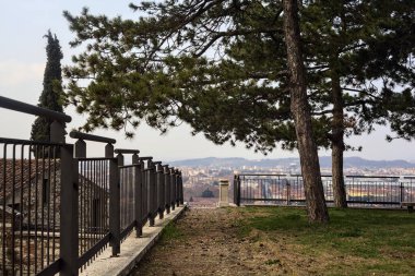 Balustrade ağaçların yanında bir şatonun parkında, yukarıdan arka plan olarak görünen bir şehir.