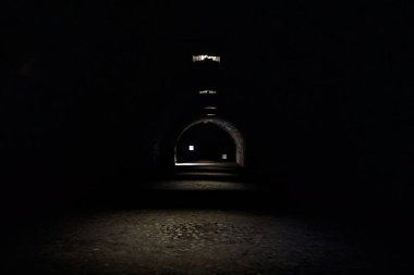 Bir kalenin sınır duvarında karanlık ve örtülü bir geçit.