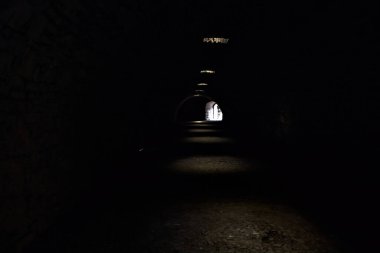 Bir kalenin sınır duvarında karanlık ve örtülü bir geçit.