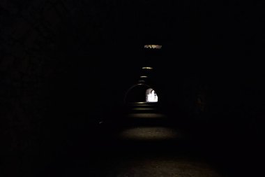 Bir kalenin sınır duvarında karanlık ve örtülü bir geçit.