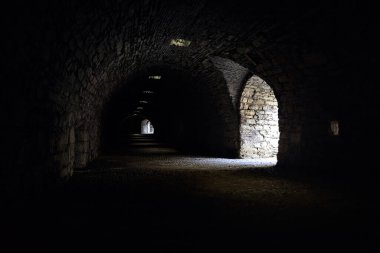 Bir kalenin sınır duvarında karanlık ve örtülü bir geçit.