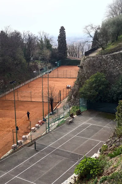 Tennis court in a park of a castle on a cloudy day seen from above