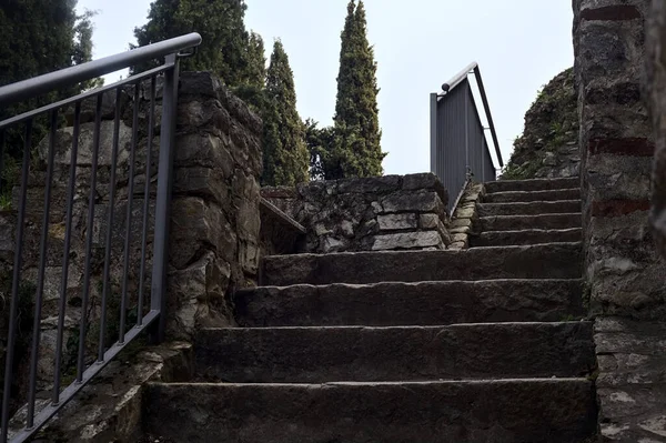 Stone staircase next to the boundary wall of a castle in a park