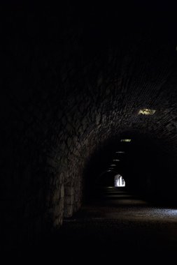 Bir kalenin sınır duvarında karanlık ve örtülü bir geçit.