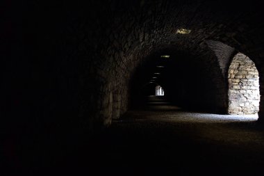 Bir kalenin sınır duvarında karanlık ve örtülü bir geçit.
