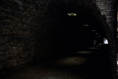 Bir kalenin sınır duvarında karanlık ve örtülü bir geçit.