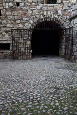 Bulutlu bir günde parktaki bir kalenin gizli geçidine giriş.