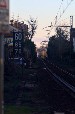 Gün batımında binalar arasındaki tren yolu.
