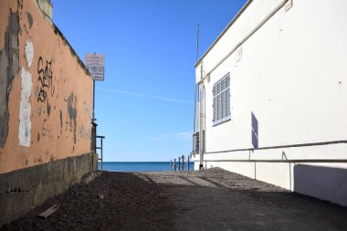 Güneşli bir günde binalar arasında kumsala erişim