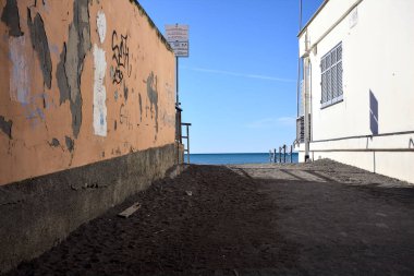 Güneşli bir günde binalar arasında kumsala erişim