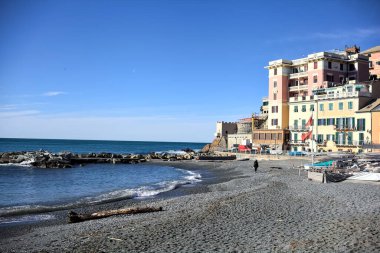 Açık bir günde, uzak bir mesafeden denize uzanan tarihi binalarla dolu bir uçurum.