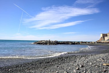 Kışın güneşli bir günde deniz ufka doğru uzanırken sahil ve dalgalı sular.