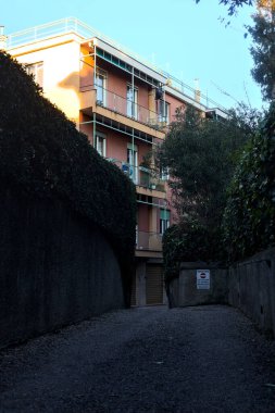 Gün batımında apartman dairesine ulaşmak için ağaçlarla çevrili gölgedeki yol.