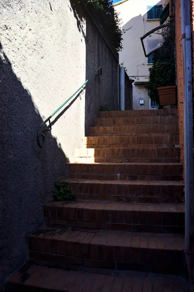 在狭窄小巷的阴凉处有栏杆的楼梯 — 图库照片