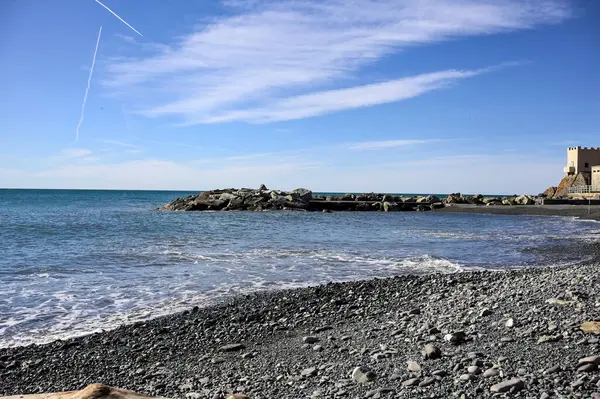 stock image Beach and breakwater with the sea stretching to the horizon on a sunny day in winter