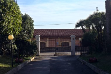 Gün batımında bir malikâneye giriş kapısı ve yol