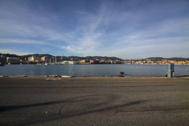 Gün batımında bir limanda nakliye ve sanayi kompleksi uzaklardan görülüyor.