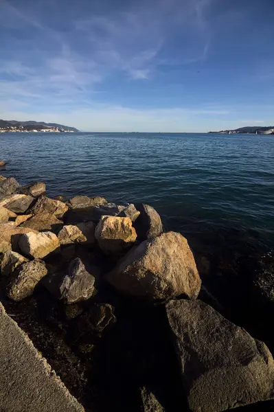 stock image Sea and the opposite shore of a lagoon in the distance framed by rocks at sunset