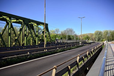 Güneşli bir günde nehri geçen bir yol ve tren yolu olan bir köprü.