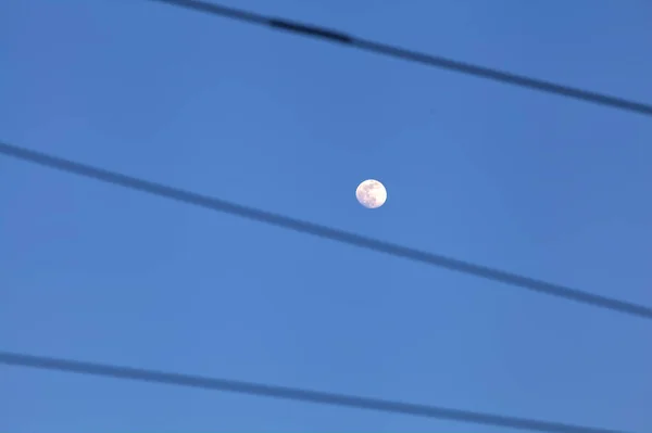 ワイヤーで囲まれた夕暮れ時の澄んだ空の満月 — ストック写真