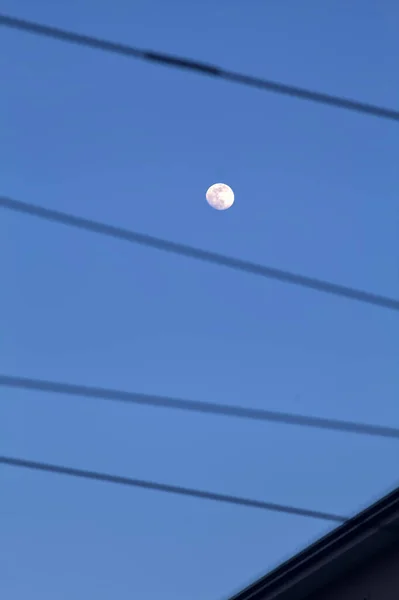 ワイヤーで囲まれた夕暮れ時の澄んだ空の満月 — ストック写真