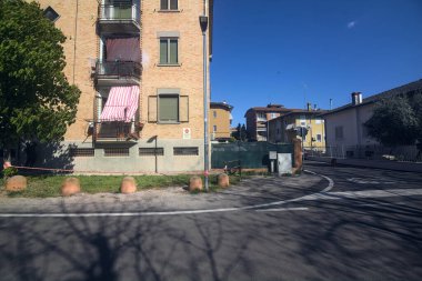 Köyün bir sokağındaki bir binanın ön cephesinde balkonlara asılı giysiler.