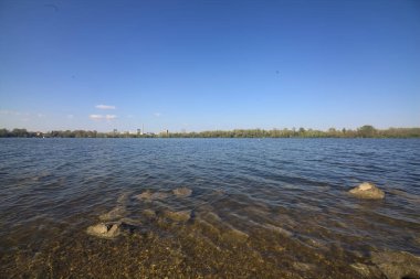 Gün batımında göl ve karşı kıyıda.