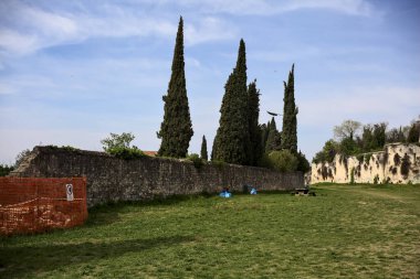 Yamaçtaki bir parkta, sınır duvarının yanında yer al.