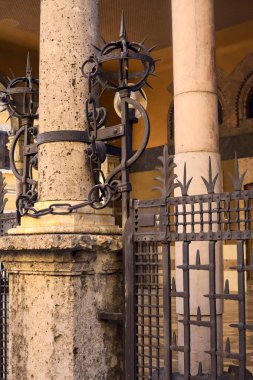 İtalya 'nın bir kasabasında lambalarla çevrili demir bir çitle çevrili boş bir kütük.