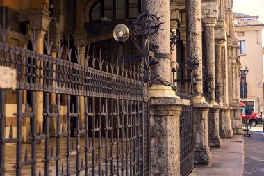 İtalya 'nın bir kasabasında lambalarla çevrili demir bir çitle çevrili boş bir kütük.