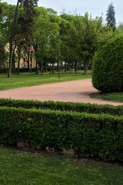 Gün batımında bir İtalyan kasabasında halka açık bir parkta yol.