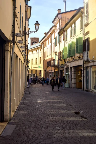 イタリアの町で晴れた日にお店や人が通り過ぎる日陰の狭い通り — ストック写真