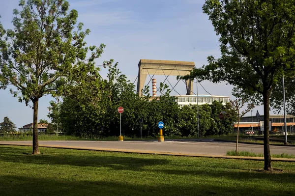 stock image Crossroads near a factory framed by trees in an italian village on a sunny day