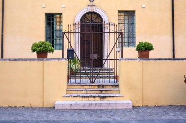 İtalya 'da bir meydanda merdivenin yanındaki kapının arkasında.