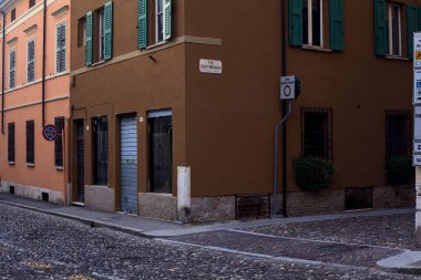 Gün batımında bir kasabanın sokaklarının kesiştiği bir binanın köşesinde.