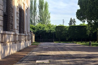 Gün batımında İtalyan kasabasında bir sarayın yanındaki parkta.