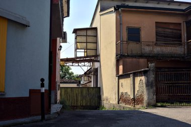 Terk edilmiş depo, İtalya 'nın kırsal kesimlerinde güneşli bir günde bir ara sokakta kapılar tarafından kapatılmış.