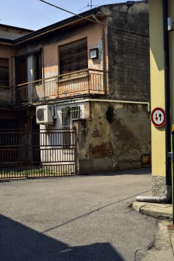 Terk edilmiş depo, İtalya 'nın kırsal kesimlerinde güneşli bir günde bir ara sokakta kapılar tarafından kapatılmış.