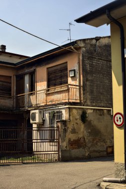Terk edilmiş depo, İtalya 'nın kırsal kesimlerinde güneşli bir günde bir ara sokakta kapılar tarafından kapatılmış.