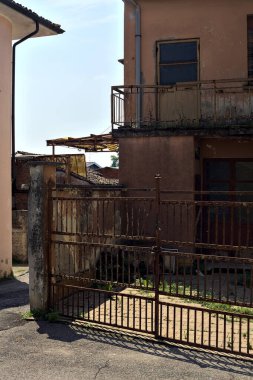 Terk edilmiş depo, İtalya 'nın kırsal kesimlerinde güneşli bir günde bir ara sokakta kapılar tarafından kapatılmış.