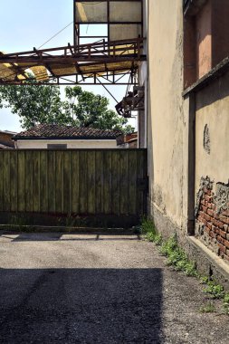 Terk edilmiş depo, İtalya 'nın kırsal kesimlerinde güneşli bir günde bir ara sokakta kapılar tarafından kapatılmış.