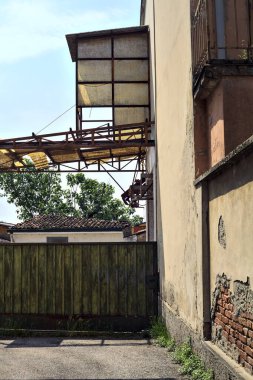 Terk edilmiş depo, İtalya 'nın kırsal kesimlerinde güneşli bir günde bir ara sokakta kapılar tarafından kapatılmış.