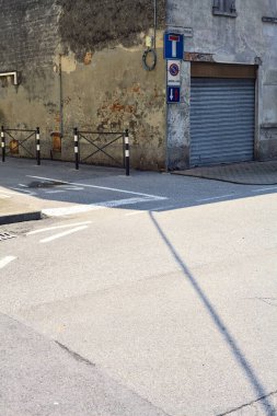 Güneşli bir günde köşesinde kapalı bir dükkan olan bir sokak ve yol arasındaki kavşak.