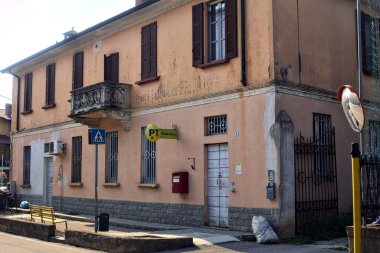 İtalyan kırsalındaki bir köyde, yolun kenarındaki postanede.