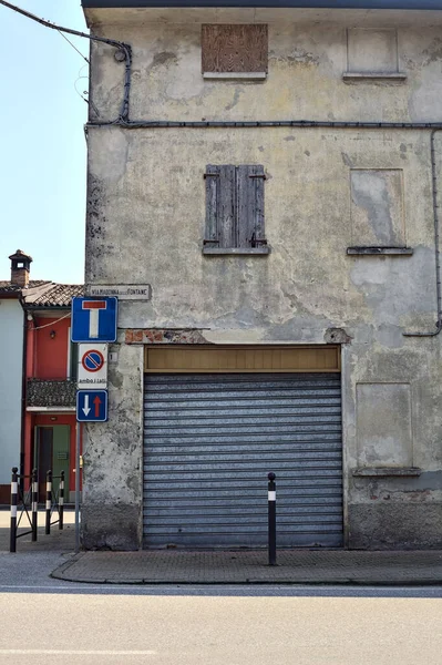 stock image Crossroads between an alley and a road with a closed shop in the corner on a sunny day